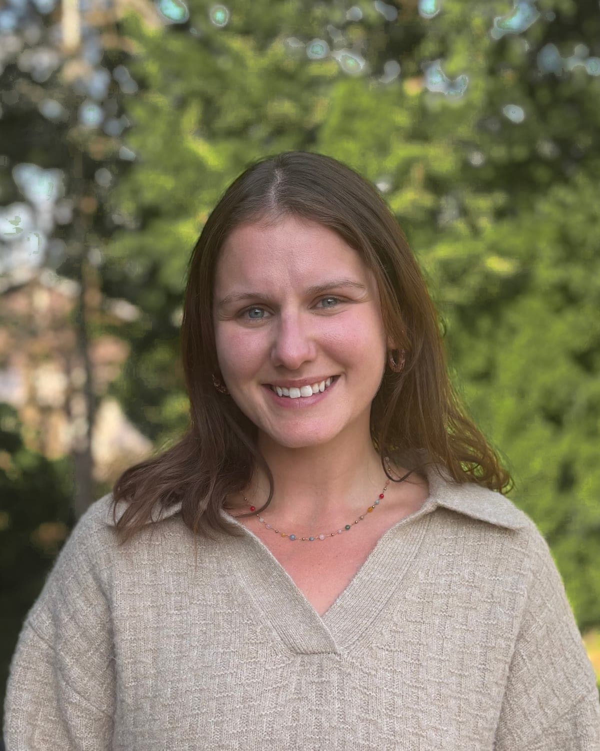 Jessica Ruppert, Registered Psychotherapist, outdoors in evening light with evergreens behind her