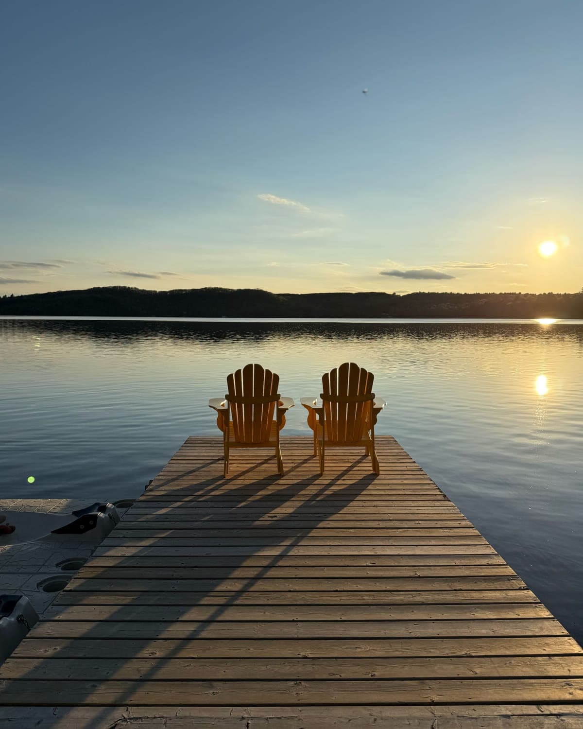 Two chairs side by side on a dock, facing out over the water